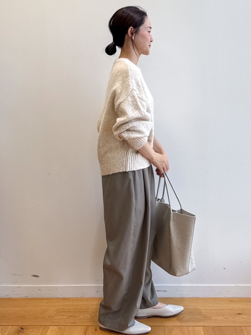 ホワイト系のニット/セーター、グリーン系のその他パンツ、ベージュ系のトートバッグを着用したレディースの夏コーディネートの2枚目の写真