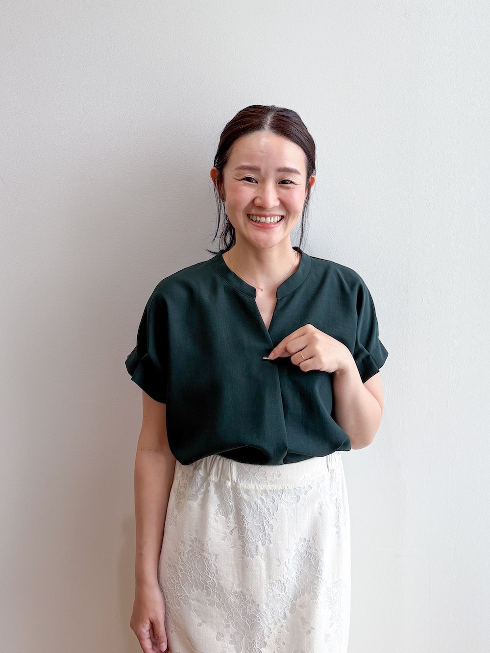 グリーン系のシャツ/ブラウス、ホワイト系のスカート、グレー系のパンプスを着用したレディースの夏コーディネートの5枚目の写真