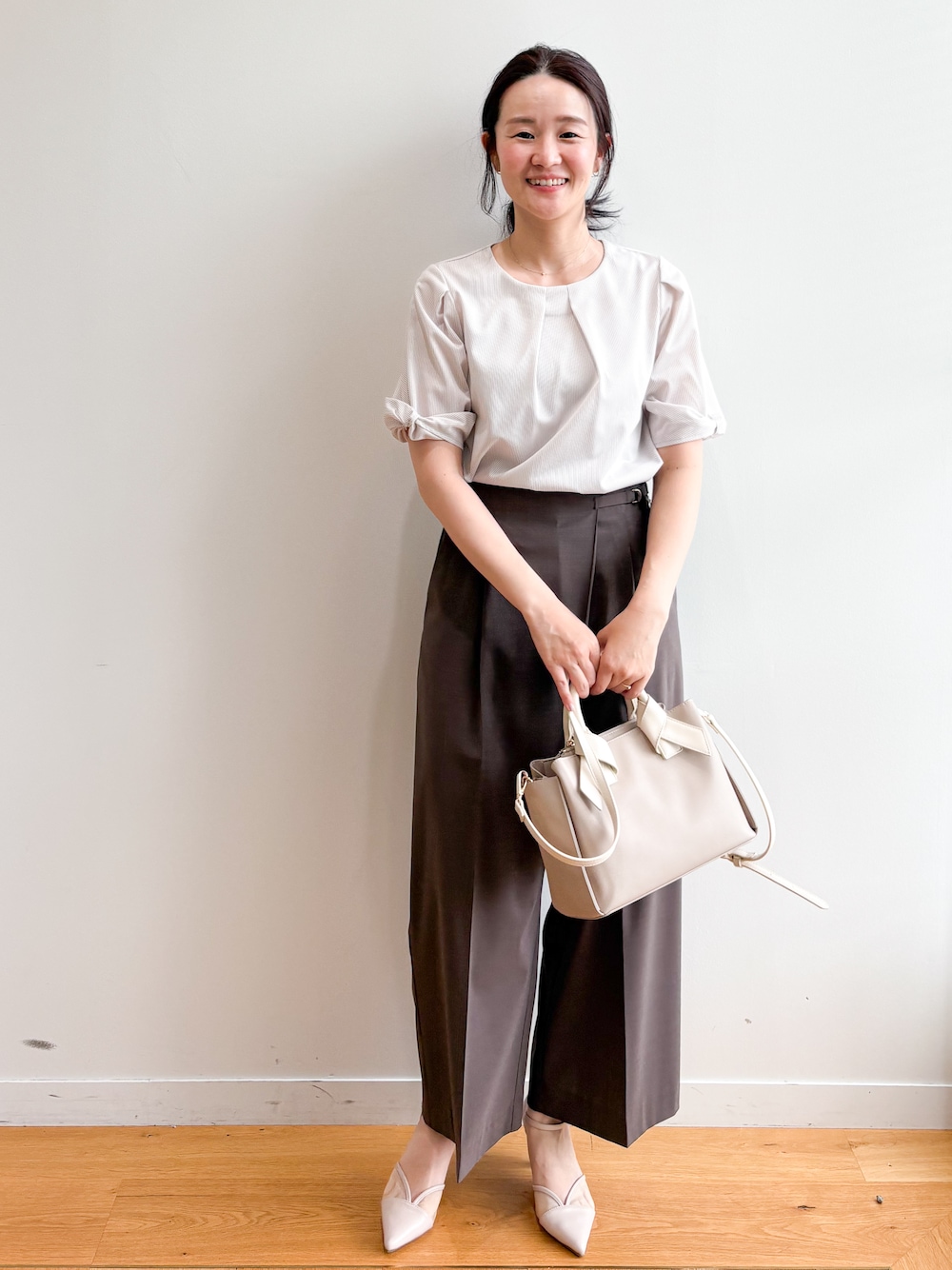 ベージュ系のトートバッグ、ベージュ系のパンプス、ベージュ系のTシャツ/カットソーを着用したレディースの夏コーディネートの2枚目の写真