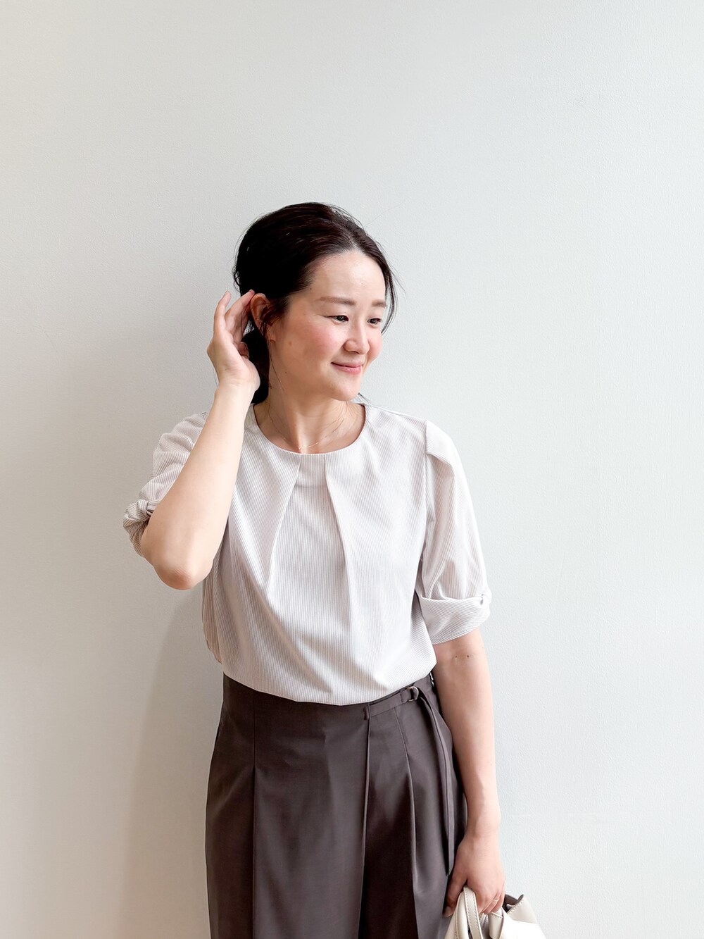 ベージュ系のトートバッグ、ベージュ系のパンプス、ベージュ系のTシャツ/カットソーを着用したレディースの夏コーディネートの6枚目の写真