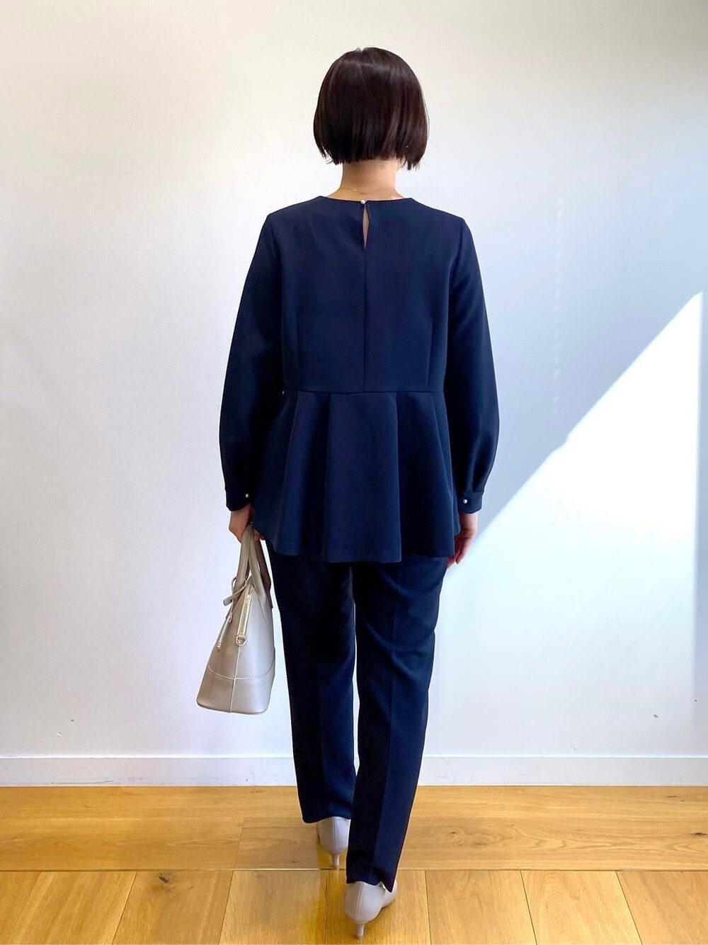 ブルー系のシャツ/ブラウス、ブルー系のその他パンツ、ベージュ系のハンドバッグを着用したレディースの冬コーディネートの3枚目の写真