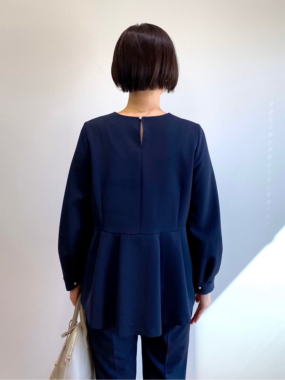 ブルー系のシャツ/ブラウス、ブルー系のその他パンツ、ベージュ系のハンドバッグを着用したレディースの冬コーディネートの7枚目の写真