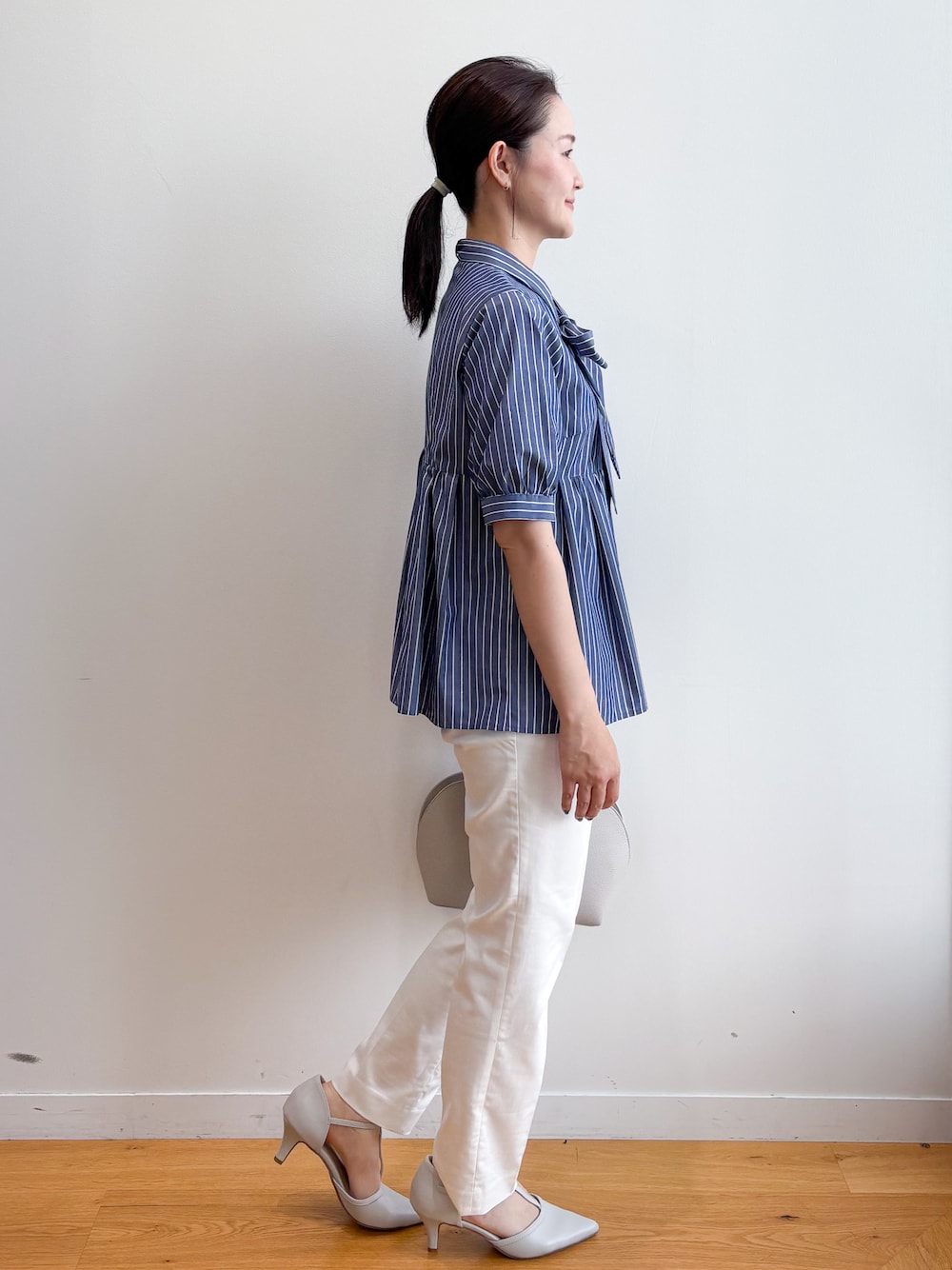 ブルー系のシャツ/ブラウス、ホワイト系のその他パンツ、ベージュ系のボストンバッグを着用したレディースの夏コーディネートの4枚目の写真