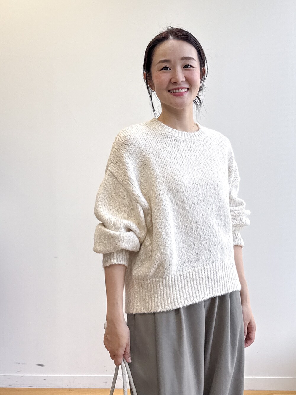 ホワイト系のニット/セーター、グリーン系のその他パンツ、ベージュ系のトートバッグを着用したレディースの夏コーディネートの5枚目の写真