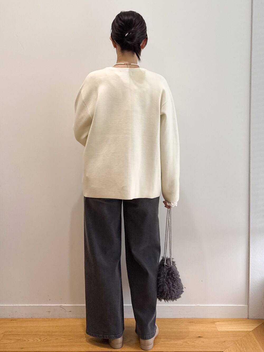 ホワイト系のカーディガン/ボレロ、ホワイト系のTシャツ/カットソー、ブラック系のデニムパンツを着用したレディースの秋コーディネートの2枚目の写真