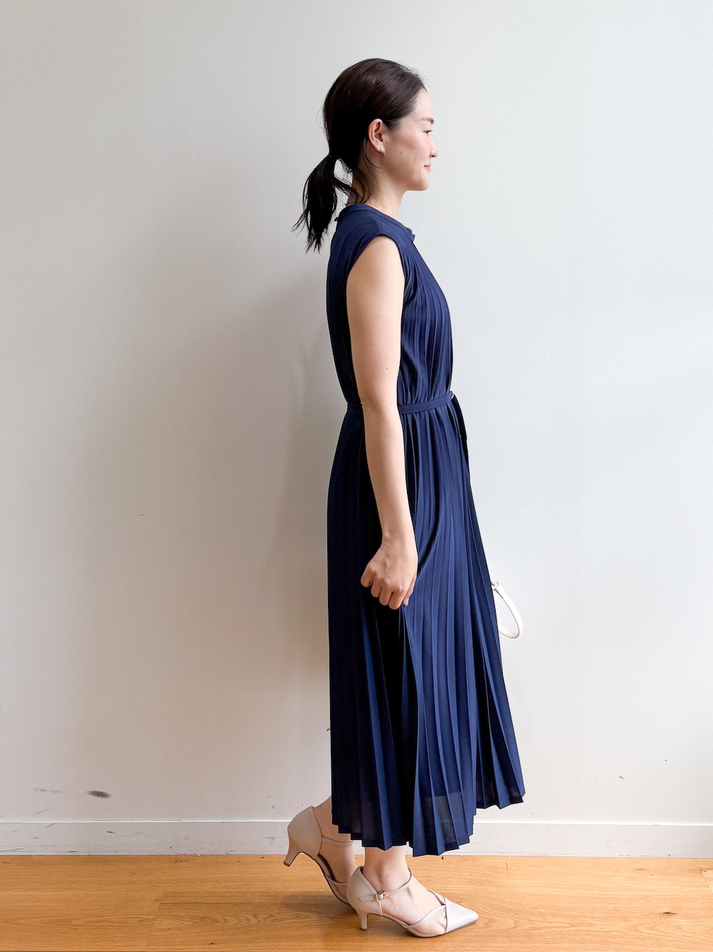ベージュ系のトートバッグ、ベージュ系のパンプス、ブルー系のワンピースを着用したレディースの夏コーディネートの3枚目の写真