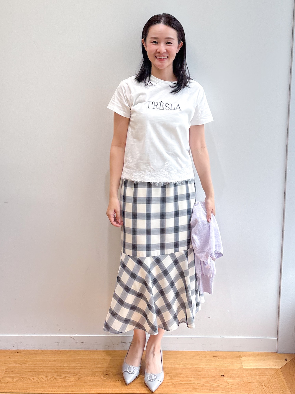 ホワイト系のTシャツ/カットソー、ホワイト系のスカート、グレー系のパンプスを着用したレディースの夏コーディネートの4枚目の写真