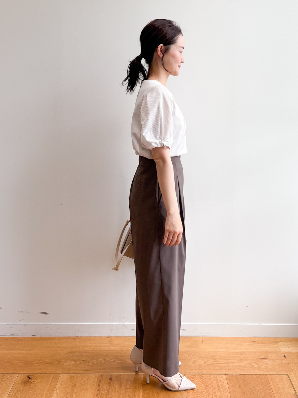 ベージュ系のトートバッグ、ベージュ系のパンプス、ベージュ系のTシャツ/カットソーを着用したレディースの夏コーディネートの3枚目の写真