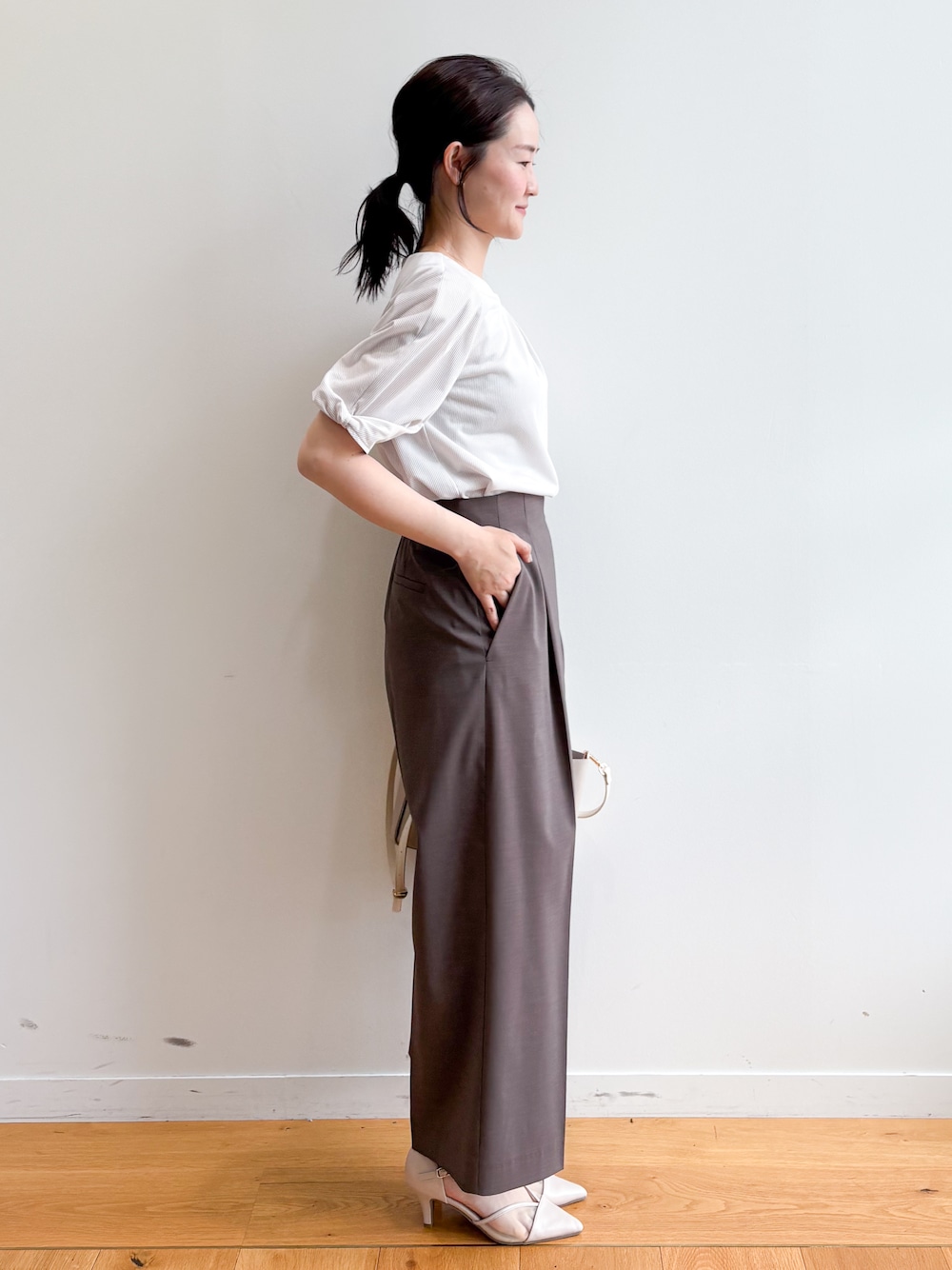 ベージュ系のトートバッグ、ベージュ系のパンプス、ベージュ系のTシャツ/カットソーを着用したレディースの夏コーディネートの4枚目の写真