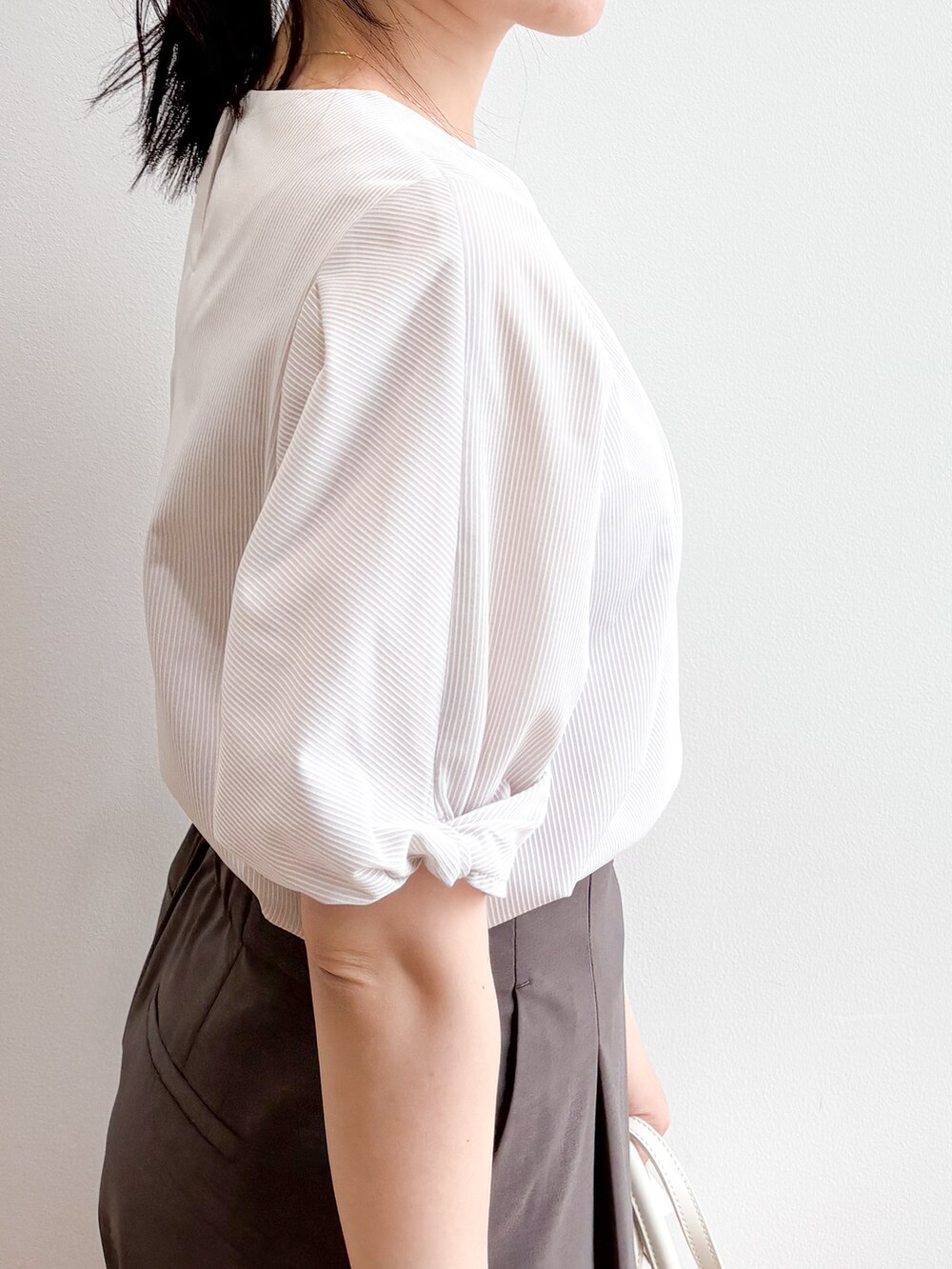 ベージュ系のトートバッグ、ベージュ系のパンプス、ベージュ系のTシャツ/カットソーを着用したレディースの夏コーディネートの7枚目の写真