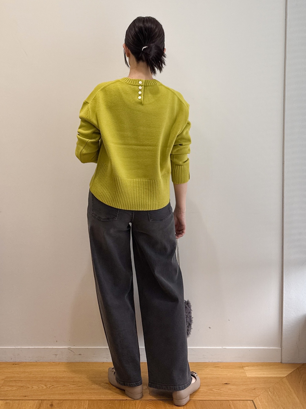 グレー系のピーコート、ブラック系のデニムパンツ、ベージュ系のパンプスを着用したレディースの秋コーディネートの9枚目の写真