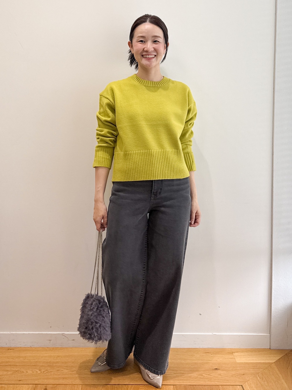 グレー系のピーコート、ブラック系のデニムパンツ、ベージュ系のパンプスを着用したレディースの秋コーディネートの7枚目の写真