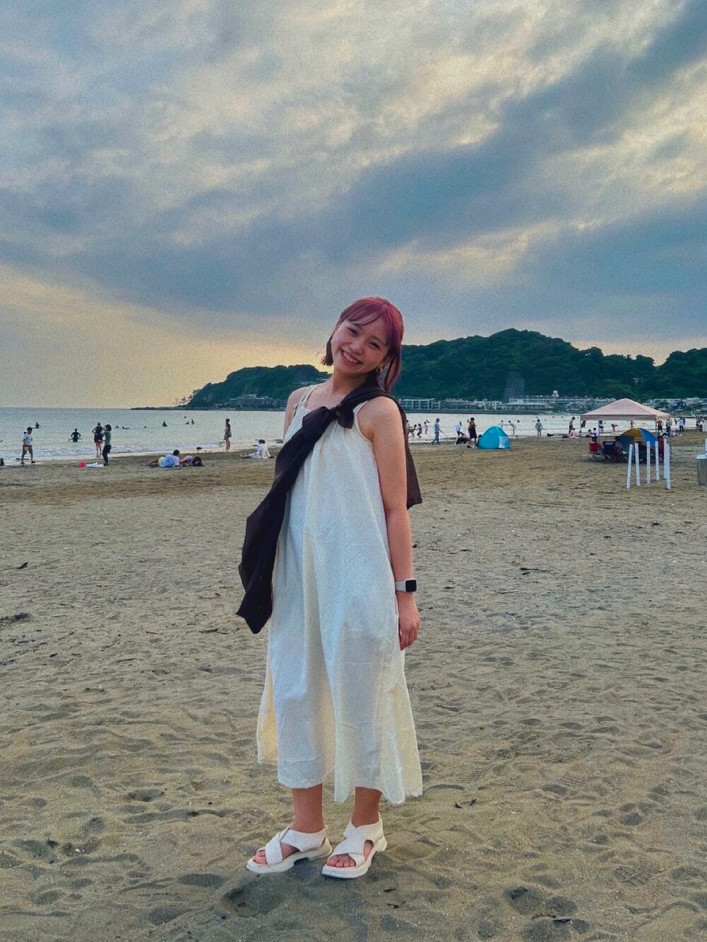 ホワイト系のサンダル、ホワイト系のワンピースを着用したレディースの夏コーディネートの2枚目の写真