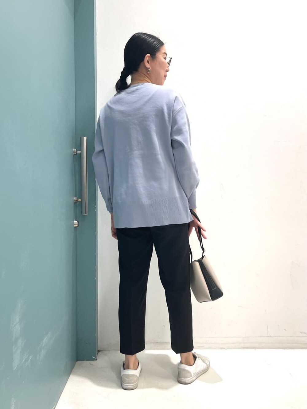 ブルー系のニット/セーター、ブラック系のその他パンツ、ブラック系のショルダーバッグを着用したレディースの冬コーディネートの4枚目の写真