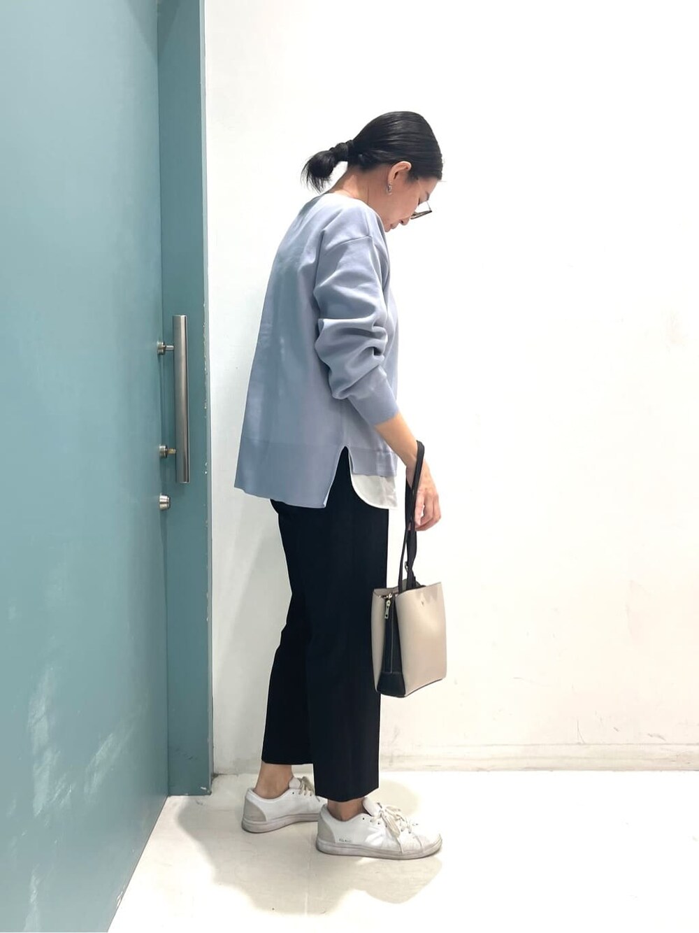 ブルー系のニット/セーター、ブラック系のその他パンツ、ブラック系のショルダーバッグを着用したレディースの冬コーディネートの3枚目の写真