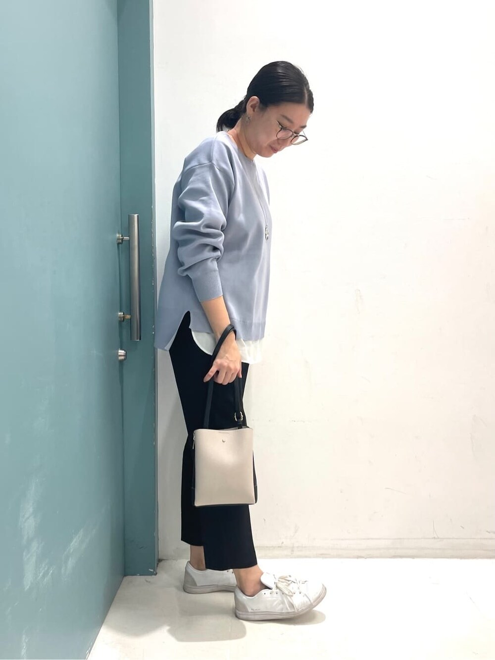 ブルー系のニット/セーター、ブラック系のその他パンツ、ブラック系のショルダーバッグを着用したレディースの冬コーディネートの2枚目の写真