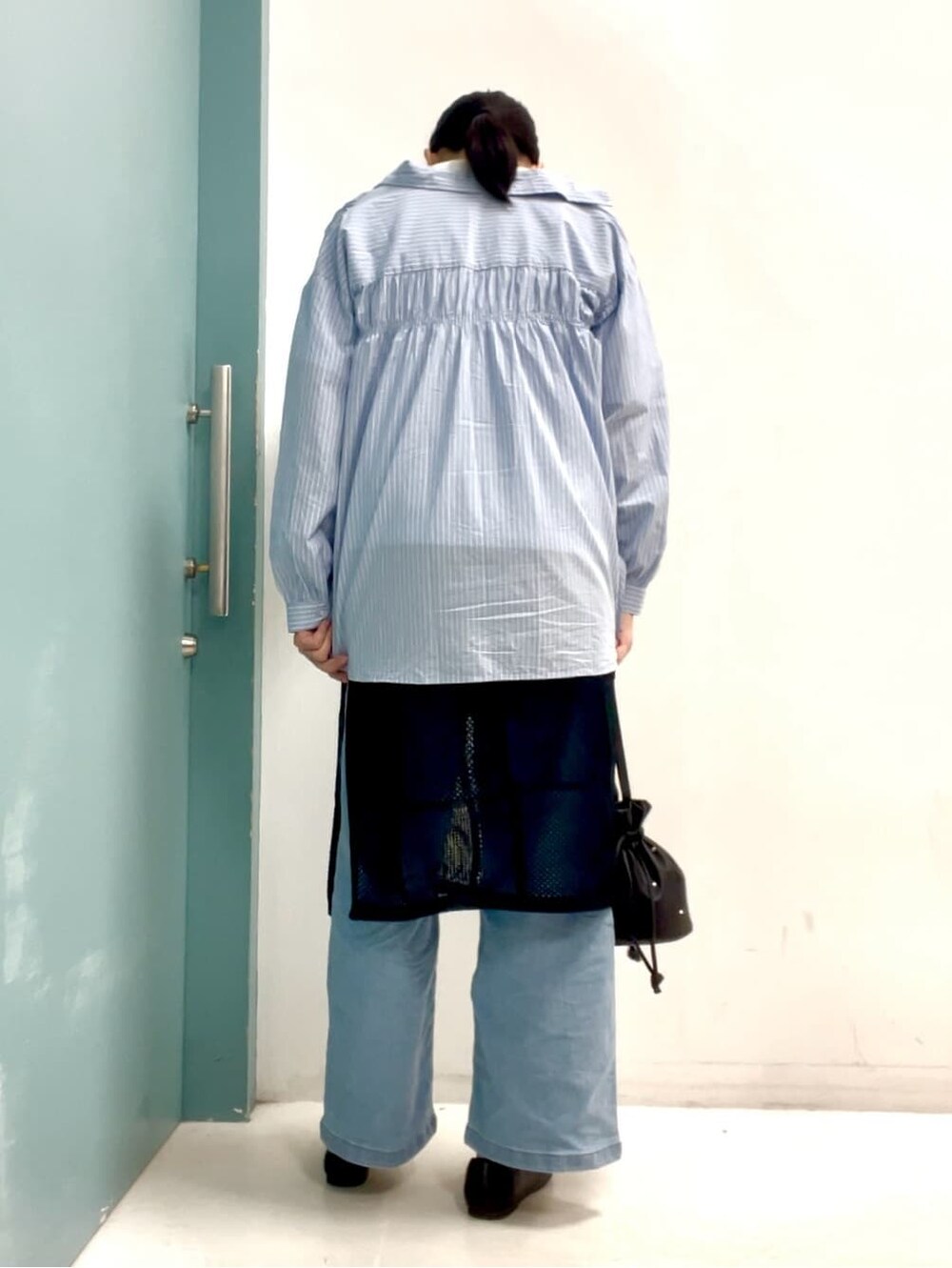 ブルー系のシャツ/ブラウス、ホワイト系のTシャツ/カットソー、ブラック系のスカートを着用したレディースの春コーディネートの3枚目の写真