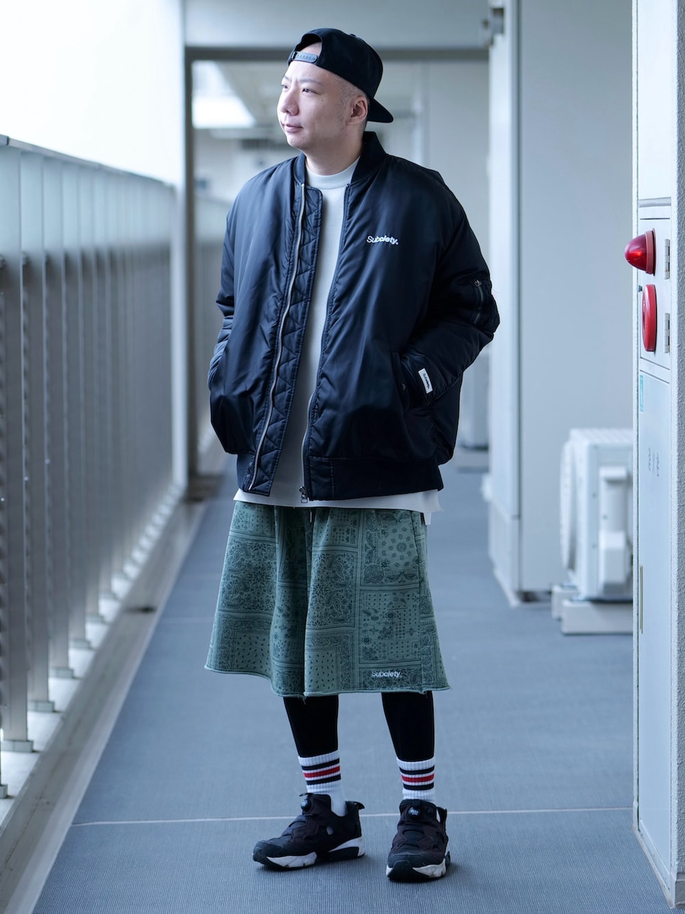 ブラック系のMA-1、ベージュ系のTシャツ/カットソー、グリーン系のスウェットパンツを着用したメンズの秋コーディネートの2枚目の写真