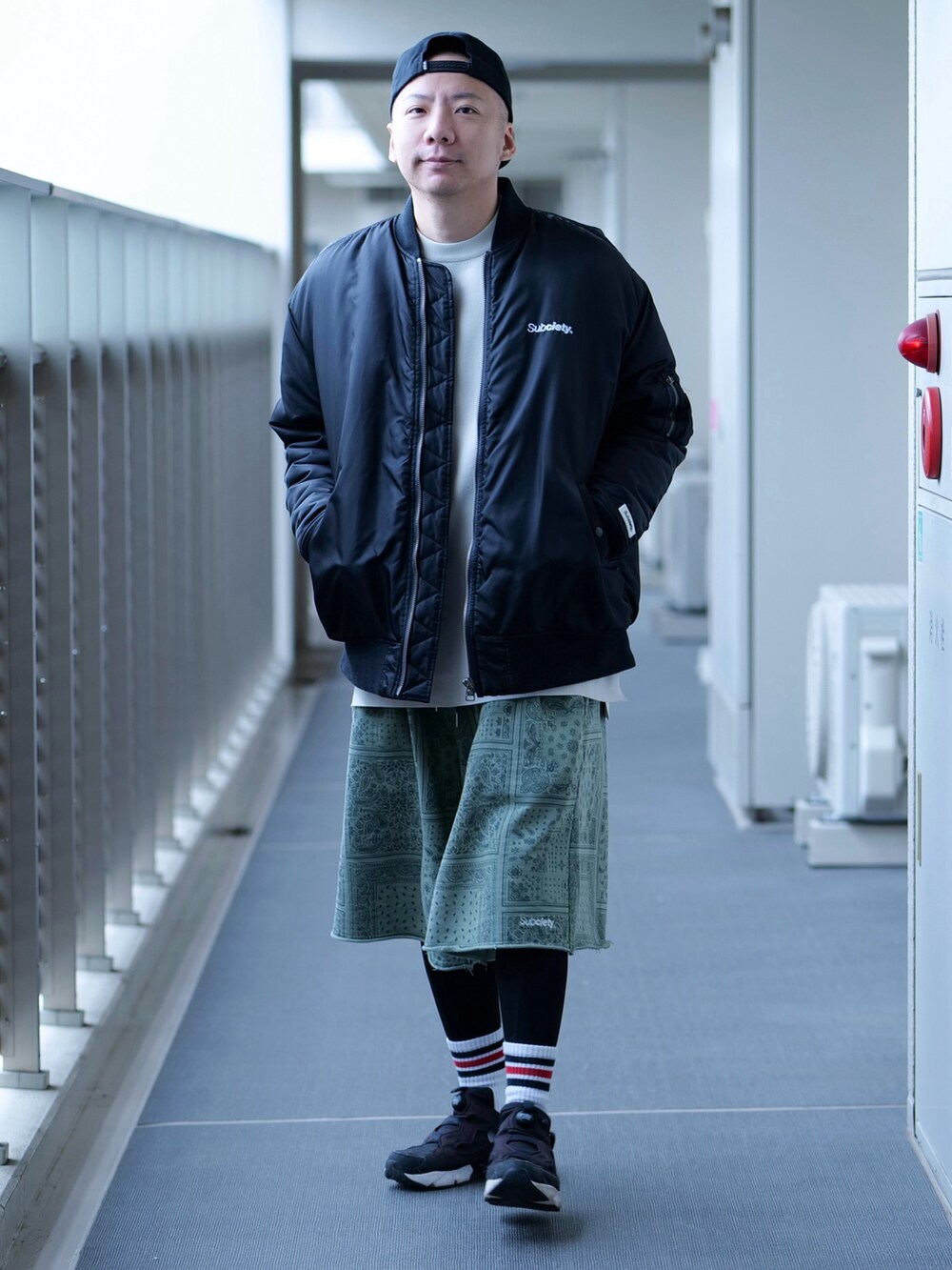 ブラック系のMA-1、ベージュ系のTシャツ/カットソー、グリーン系のスウェットパンツを着用したメンズの秋コーディネートの4枚目の写真