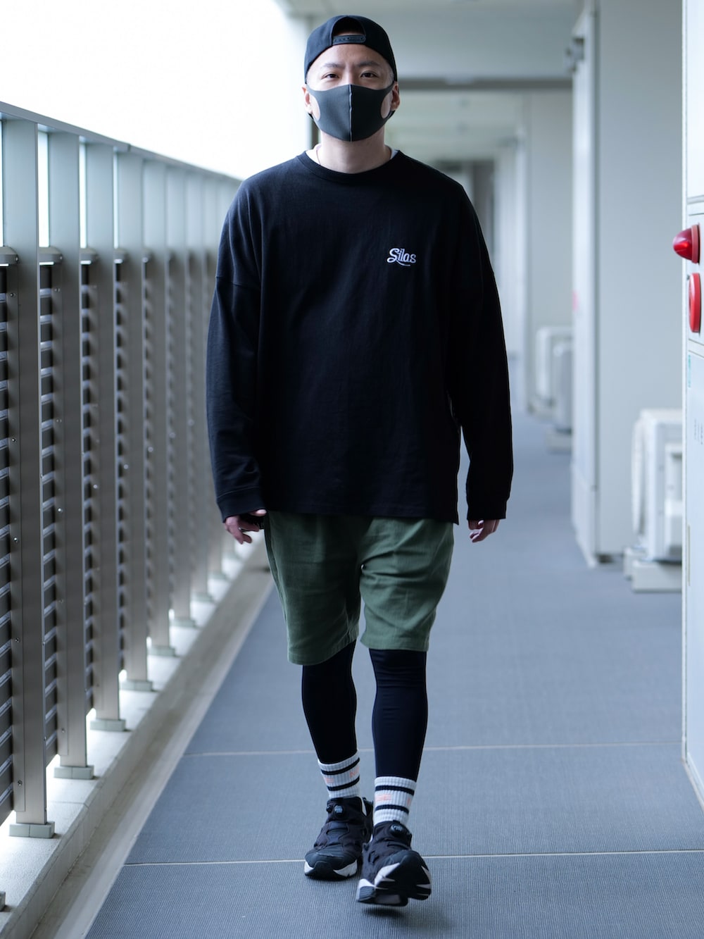 ブラック系のTシャツ/カットソー、グリーン系のその他パンツ、ブラック系のスニーカーを着用したメンズの春コーディネートの3枚目の写真