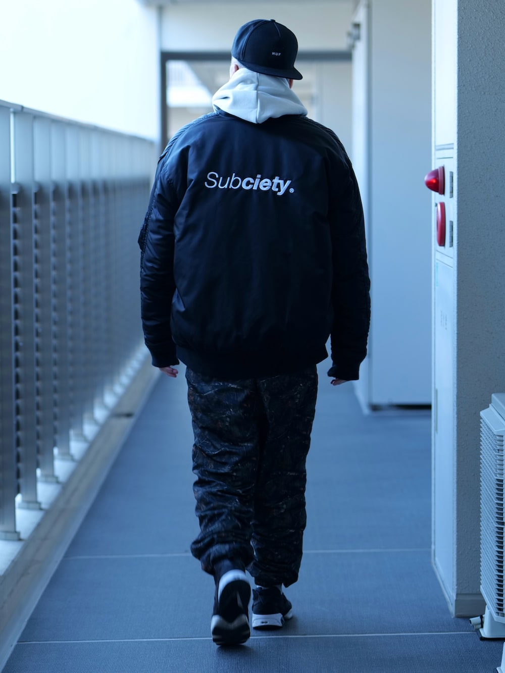 グレー系のパーカー、ブラック系のMA-1、ホワイト系のTシャツ/カットソーを着用したメンズの秋コーディネートの3枚目の写真