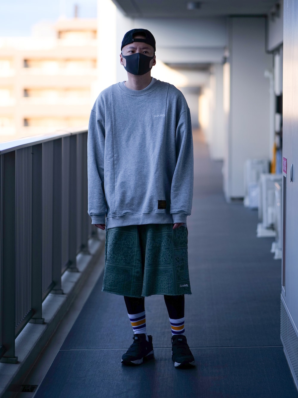 グレー系のスウェット、グリーン系のスウェットパンツ、ブラック系のスニーカーを着用したメンズの春コーディネートの2枚目の写真