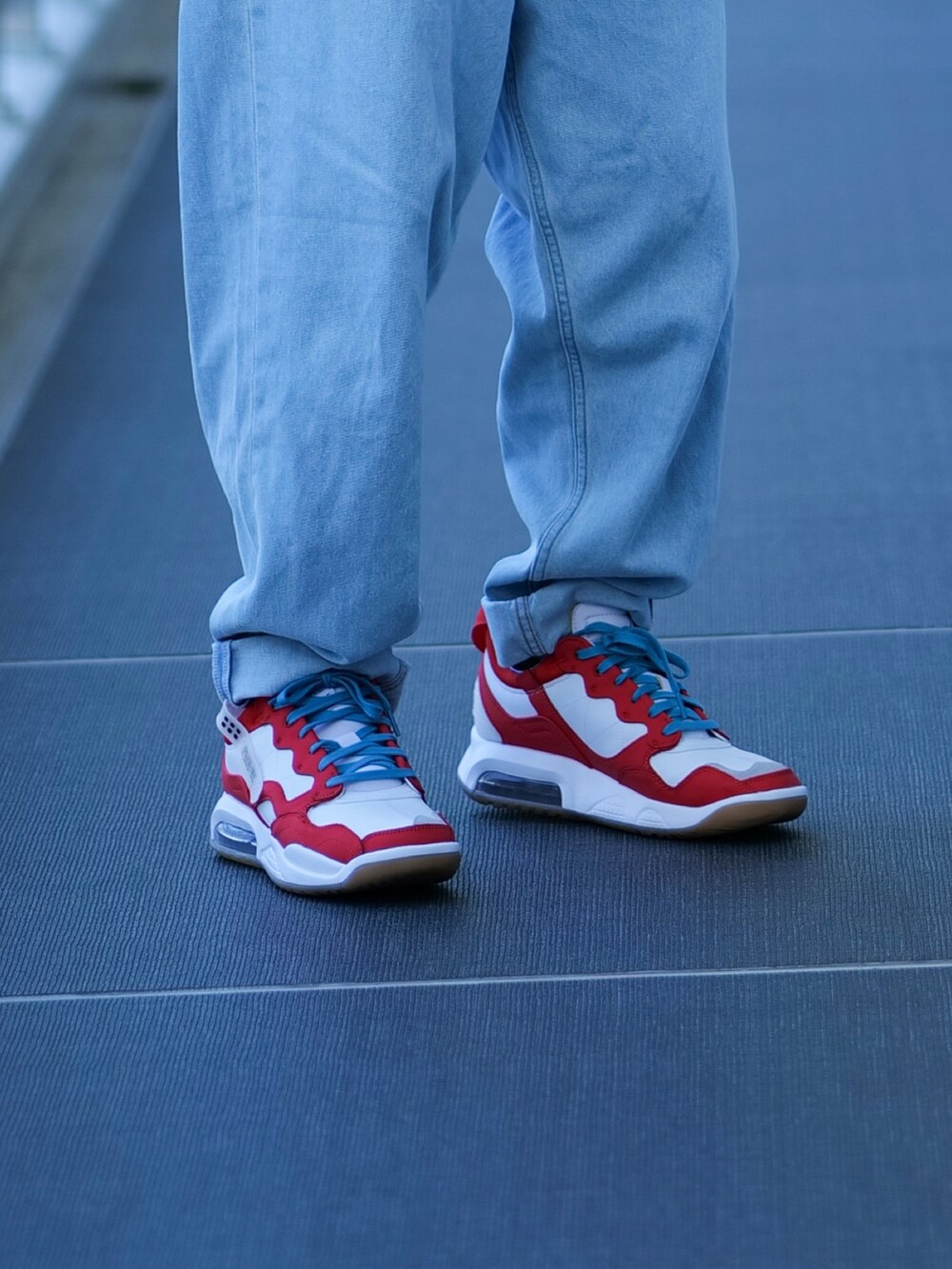 ブラック系のTシャツ/カットソー、ブルー系のデニムパンツ、ホワイト系のスニーカーを着用したメンズの夏コーディネートの2枚目の写真