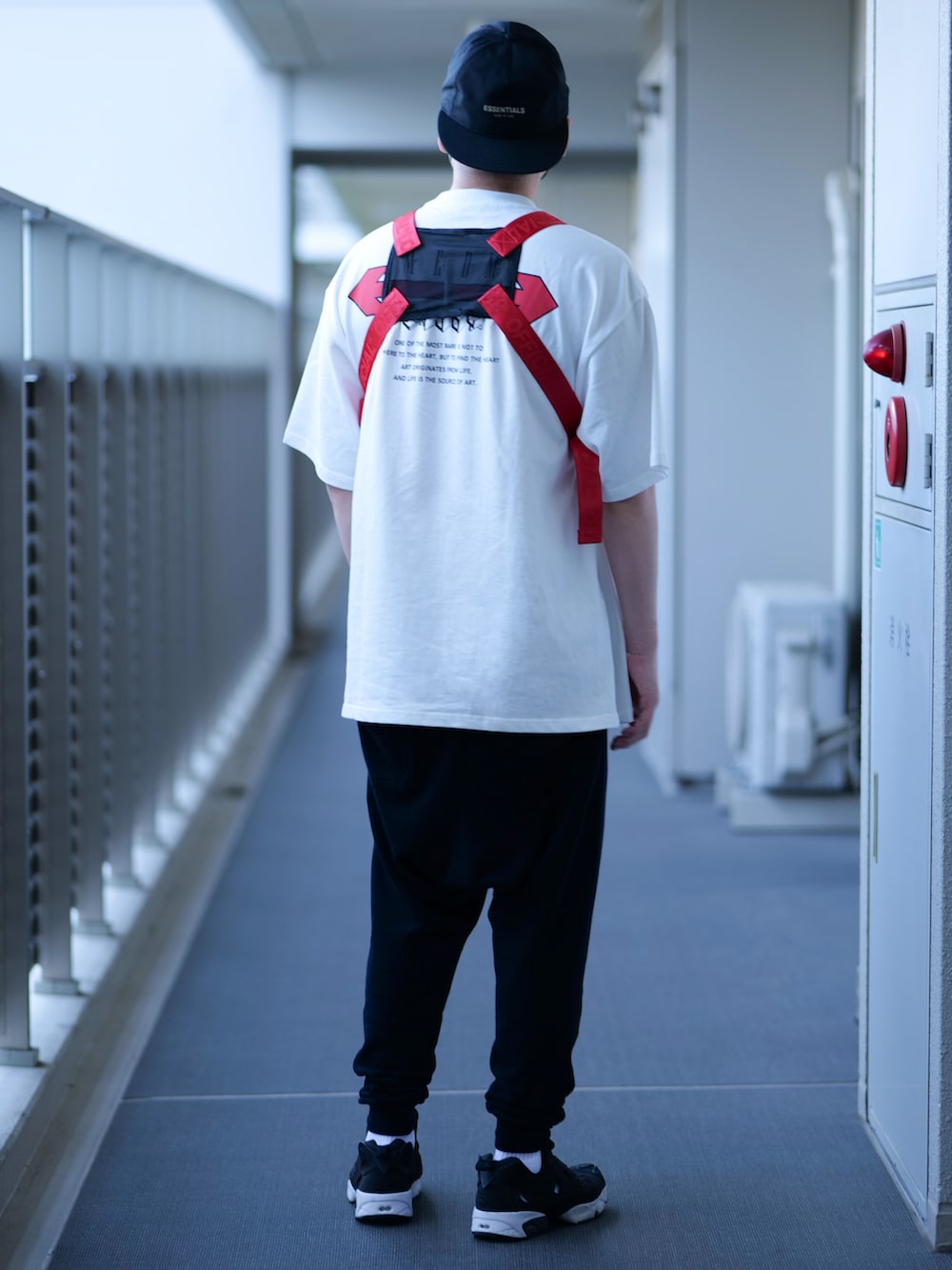 ブラック系のボディバッグ/ウエストポーチ、ホワイト系のTシャツ/カットソー、ブラック系のスウェットパンツを着用したメンズの春コーディネートの2枚目の写真