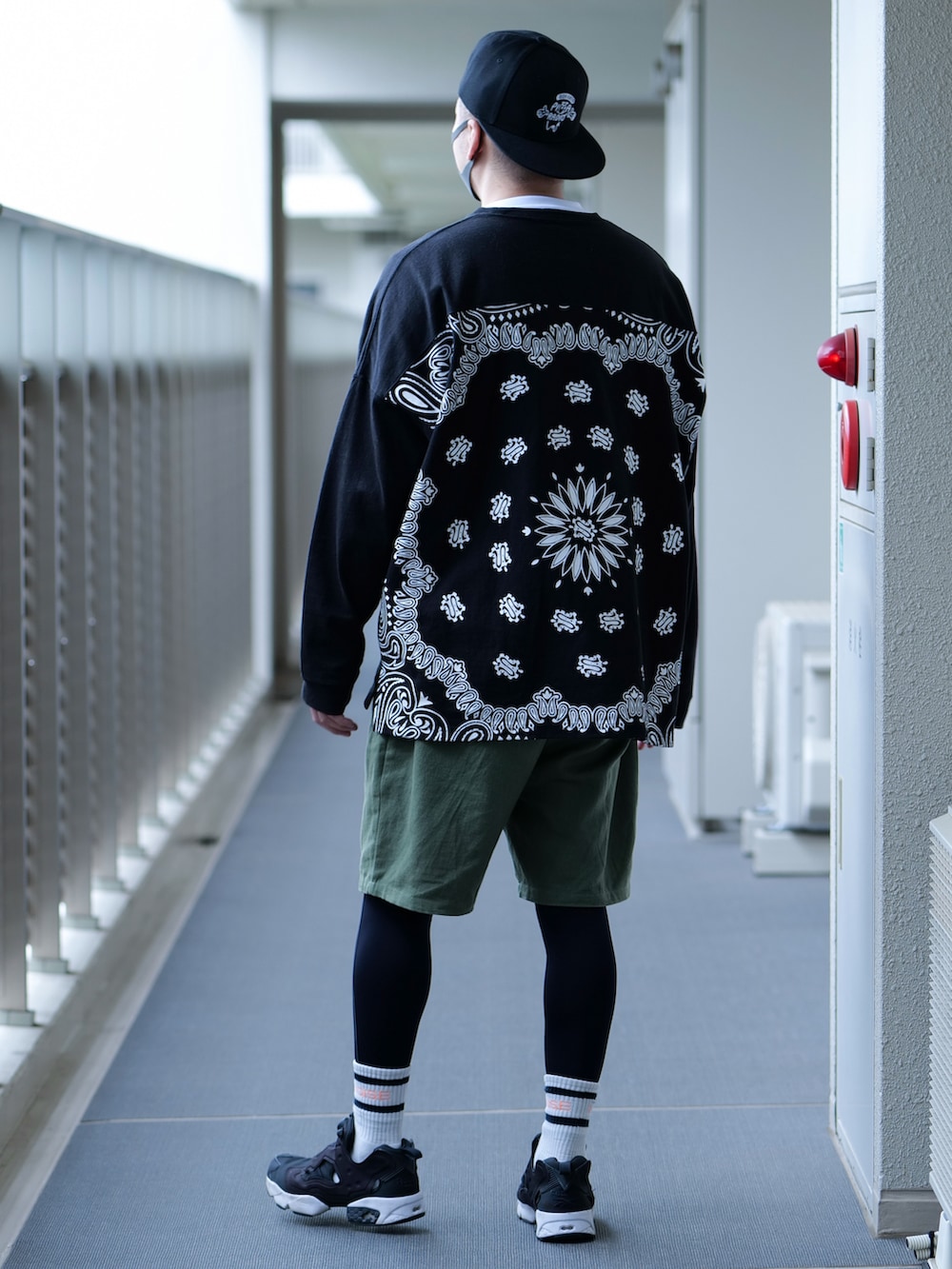 ブラック系のTシャツ/カットソー、グリーン系のその他パンツ、ブラック系のスニーカーを着用したメンズの春コーディネートの2枚目の写真