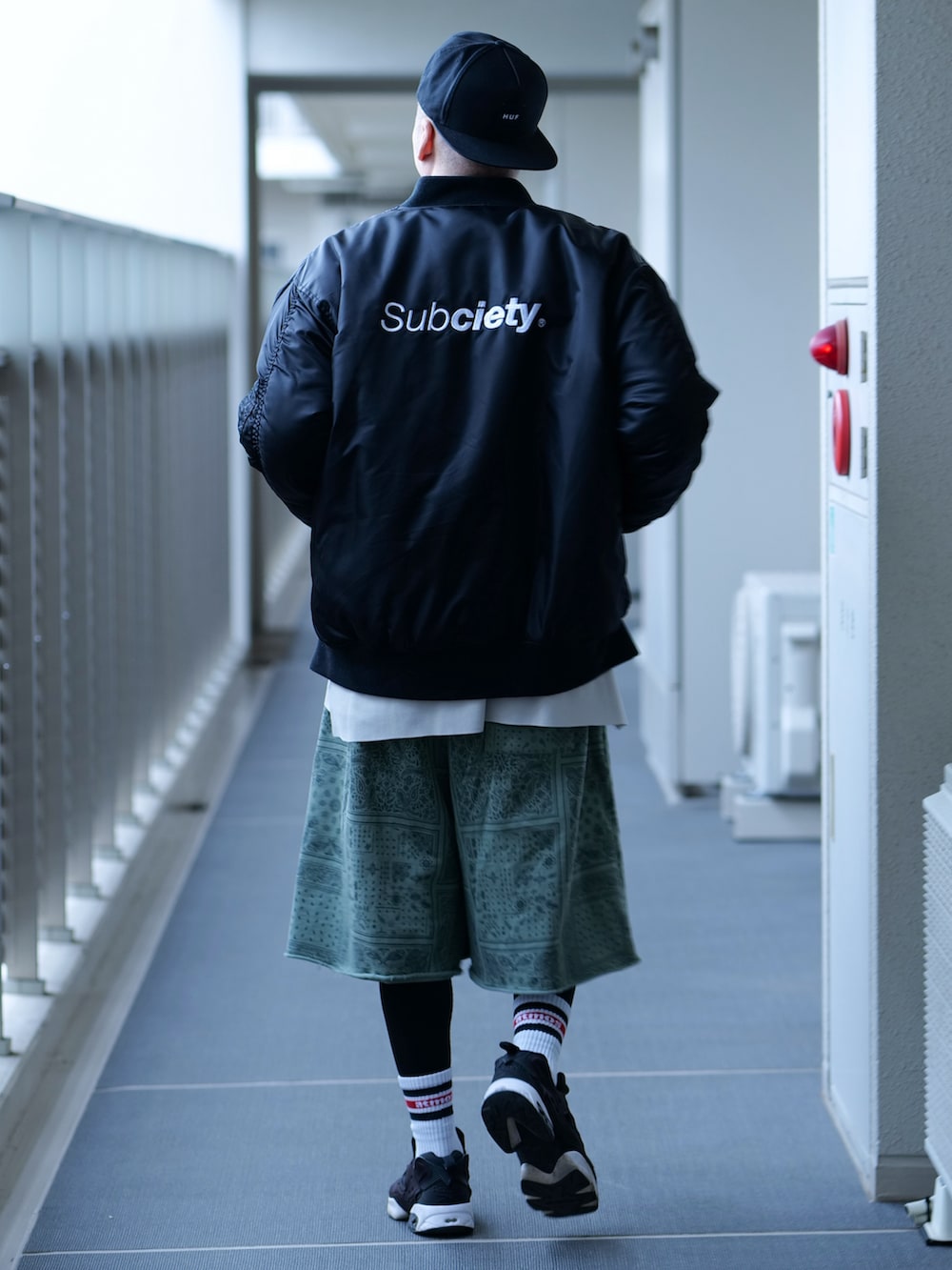 ブラック系のMA-1、ベージュ系のTシャツ/カットソー、グリーン系のスウェットパンツを着用したメンズの秋コーディネートの3枚目の写真