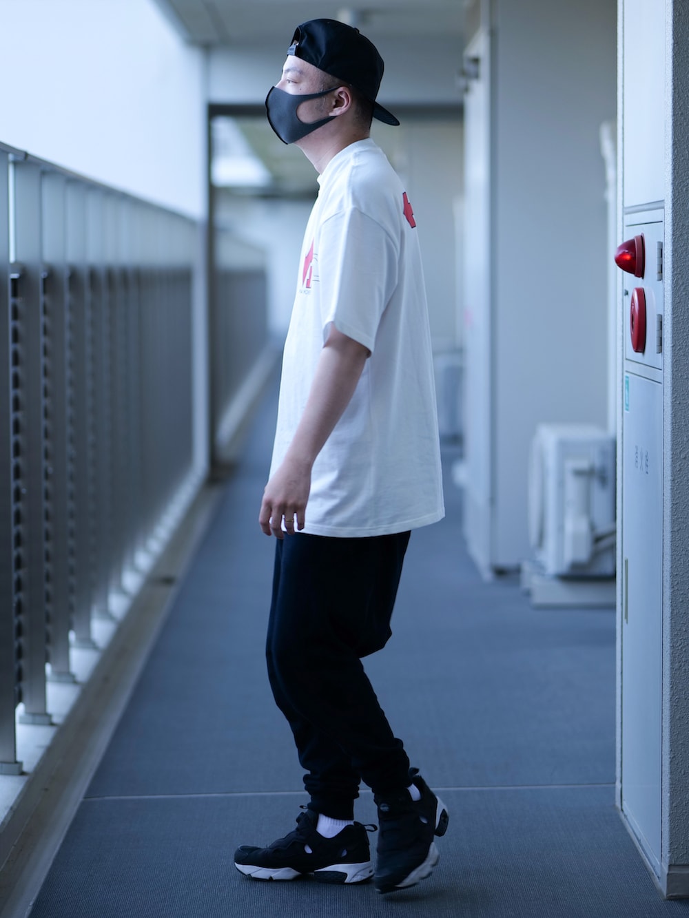 ブラック系のボディバッグ/ウエストポーチ、ホワイト系のTシャツ/カットソー、ブラック系のスウェットパンツを着用したメンズの春コーディネートの3枚目の写真