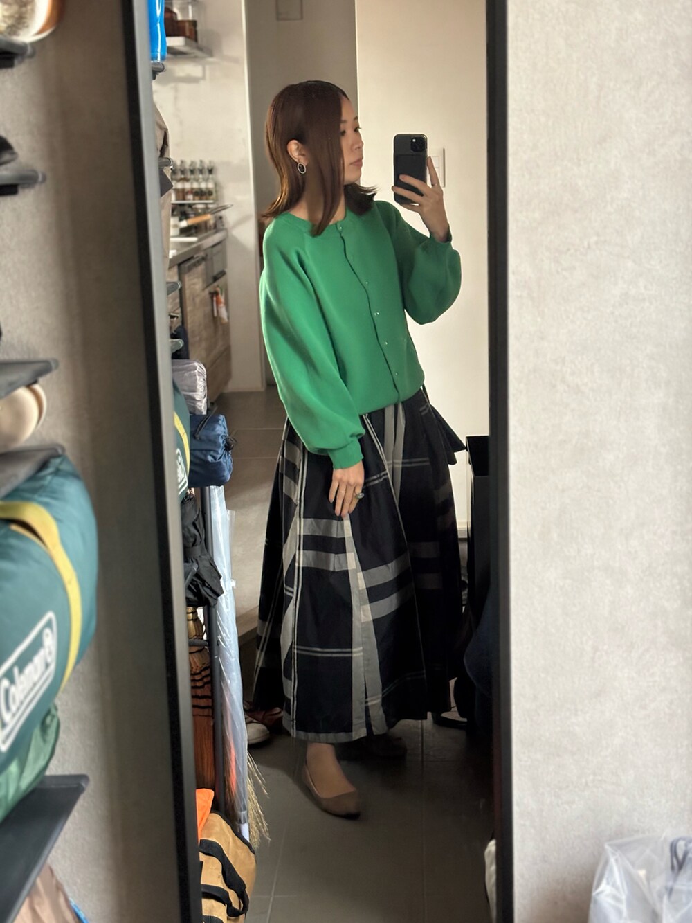 グリーン系のカーディガン/ボレロ、ブラック系のスカート、ベージュ系のパンプスを着用したレディースの秋コーディネートの2枚目の写真