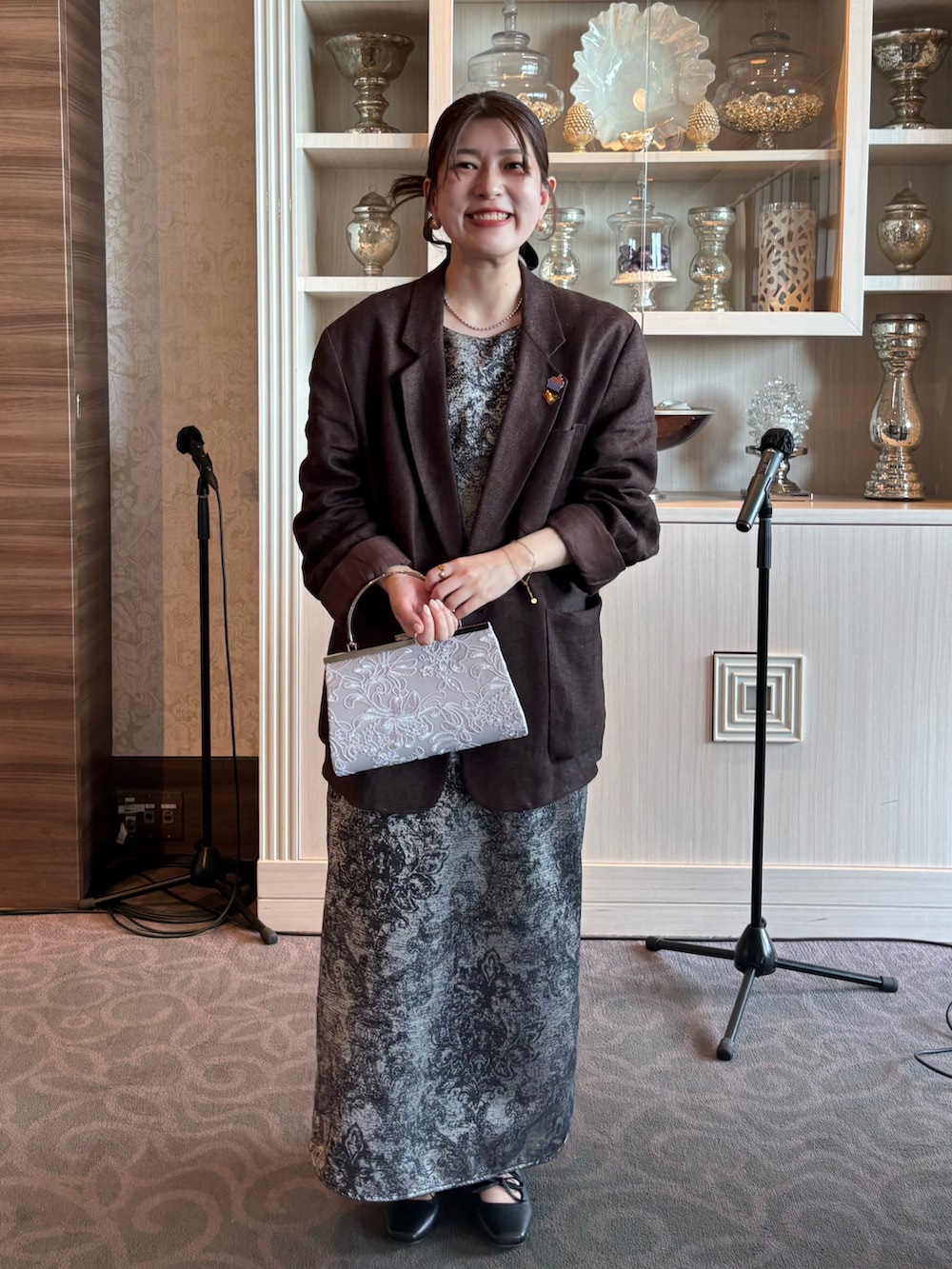 ブラック系のパンプス、ブラック系のドレス、シルバー系のハンドバッグを着用したレディースの冬コーディネートの3枚目の写真