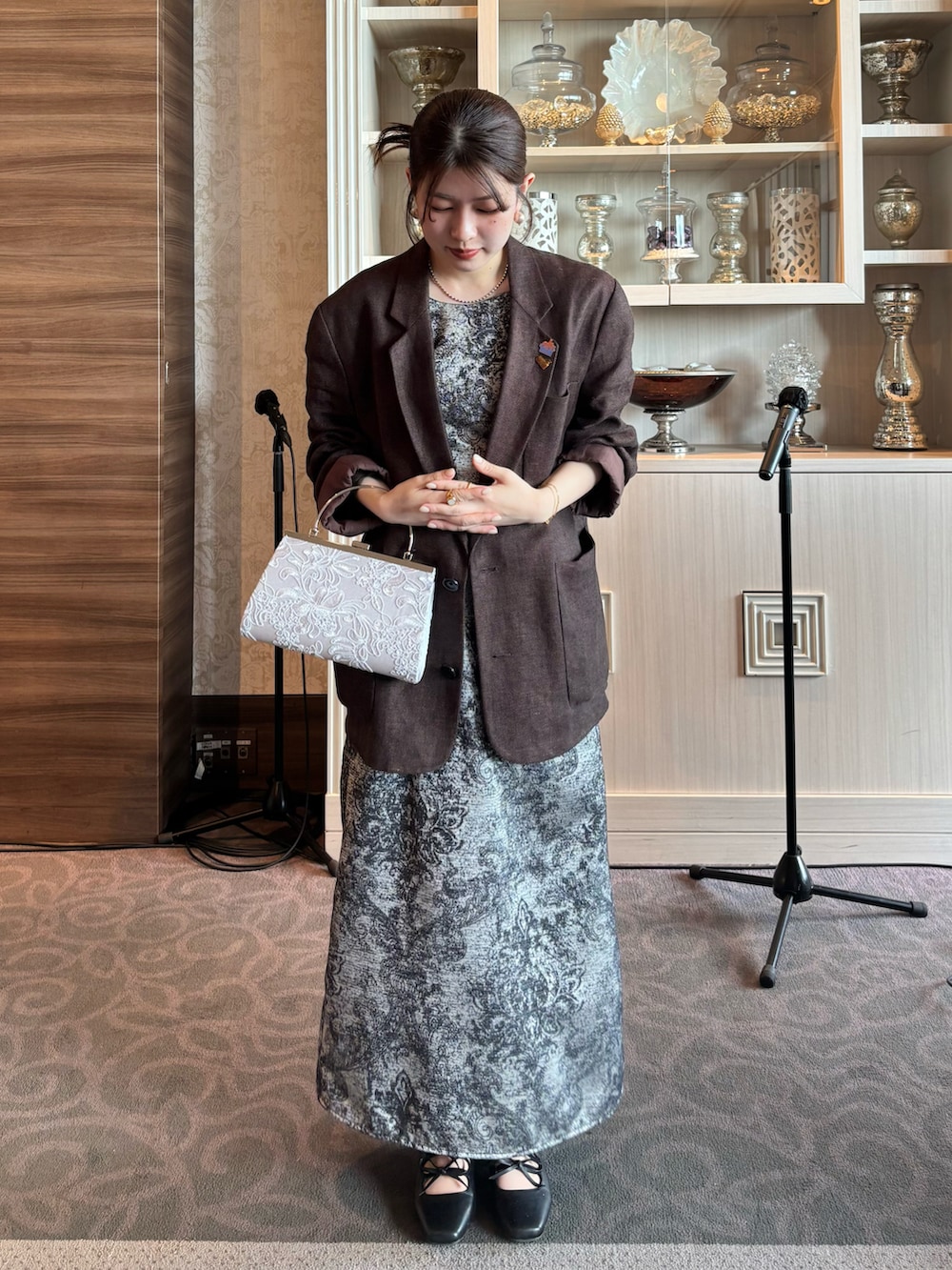 ブラック系のパンプス、ブラック系のドレス、シルバー系のハンドバッグを着用したレディースの冬コーディネートの2枚目の写真