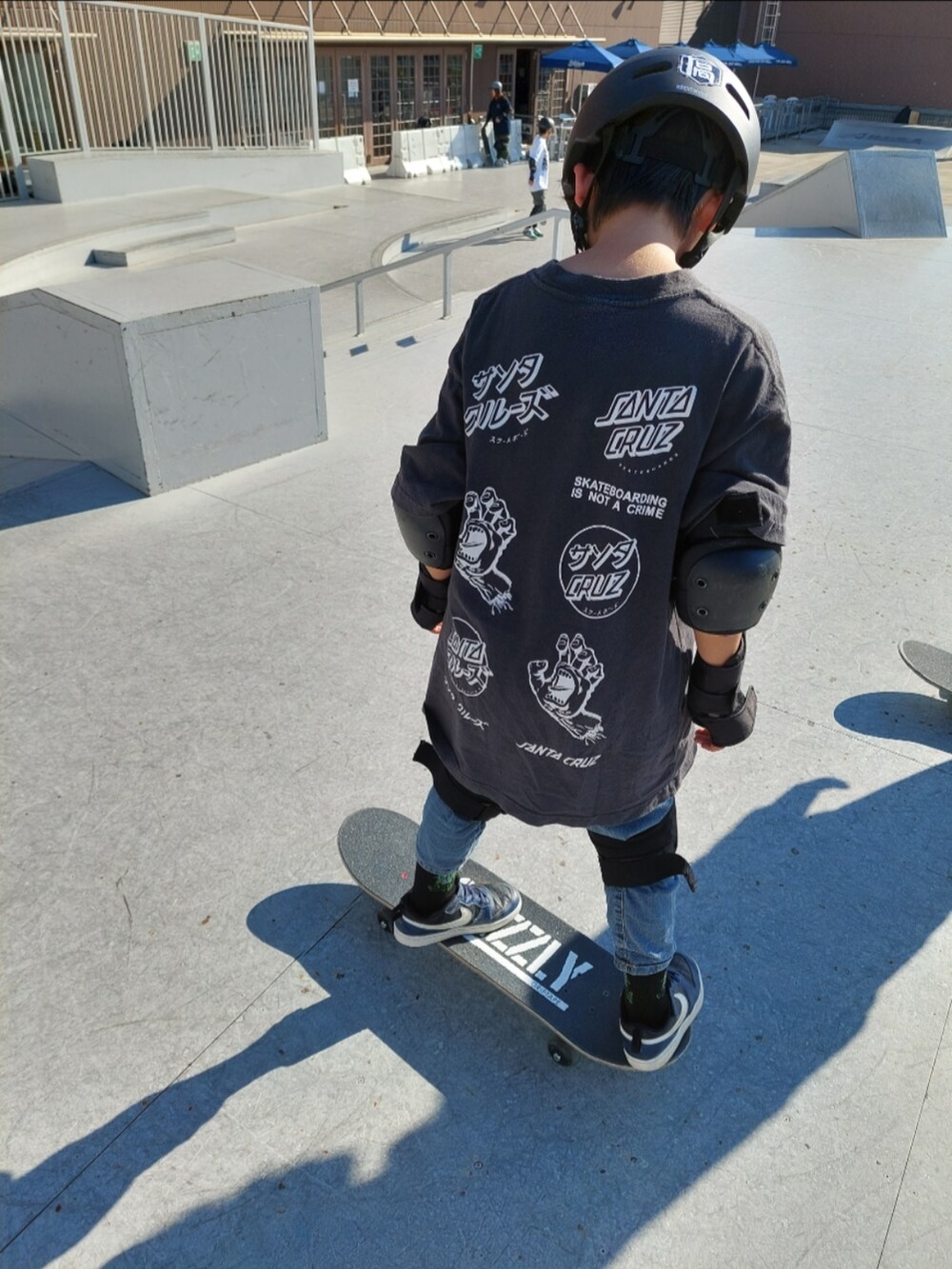 グレー系のTシャツ/カットソー、ブルー系のデニムパンツ、ブラック系のスニーカーを着用したキッズの冬コーディネートの2枚目の写真