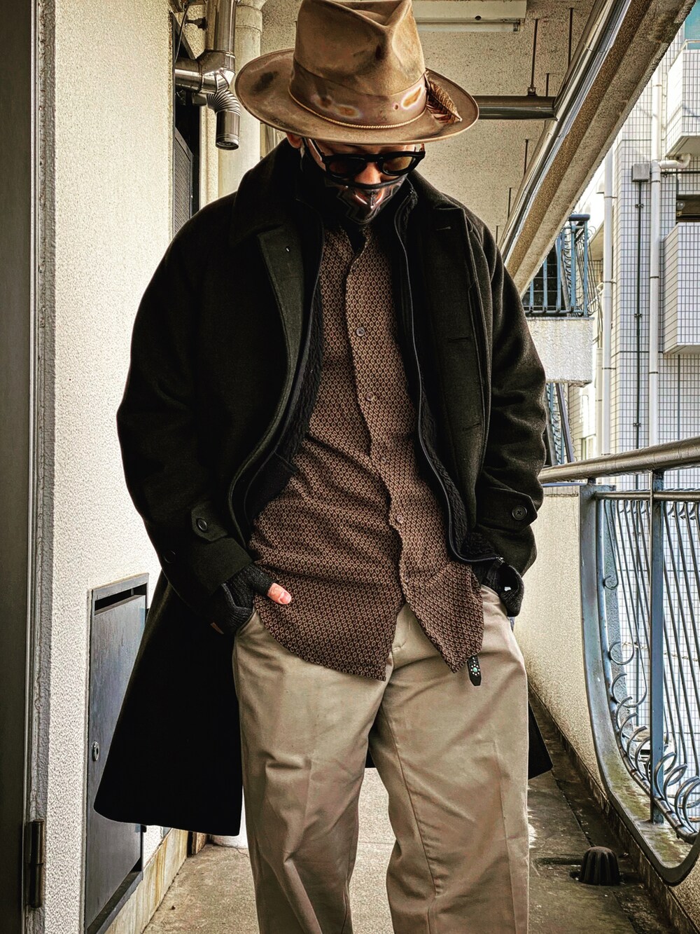 ブラック系のチェスターコート、ベージュ系のハットを着用したメンズの冬コーディネートの2枚目の写真