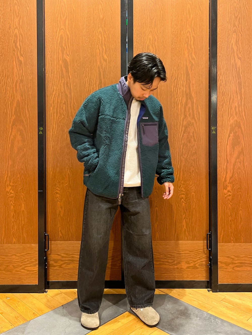 グリーン系のテーラードジャケット、グレー系のスウェット、パープル系のサンダルを着用したメンズの冬コーディネートの2枚目の写真