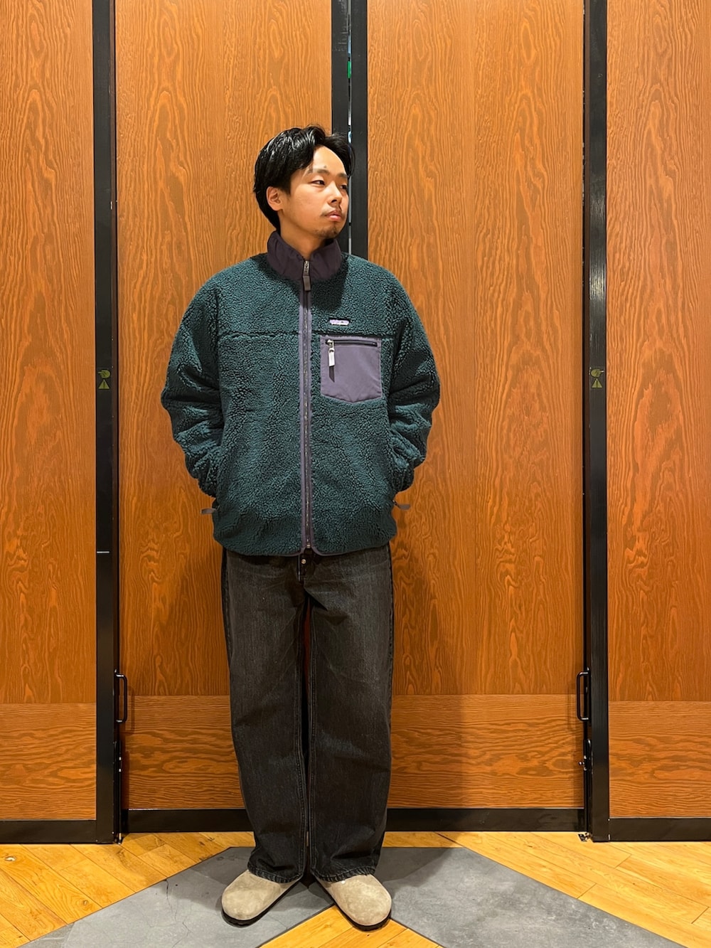 グリーン系のテーラードジャケット、グレー系のスウェット、パープル系のサンダルを着用したメンズの冬コーディネートの5枚目の写真