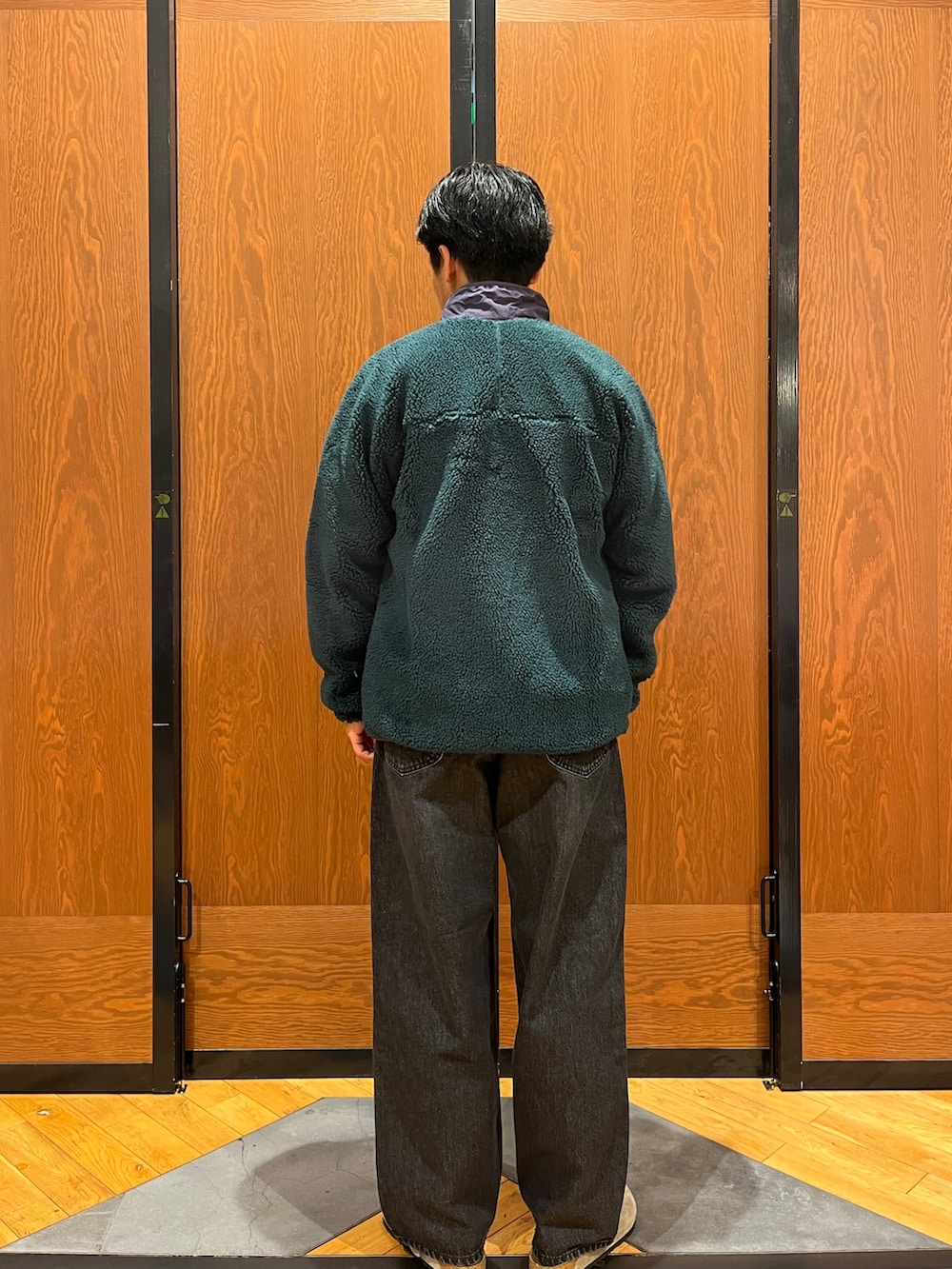 グリーン系のテーラードジャケット、グレー系のスウェット、パープル系のサンダルを着用したメンズの冬コーディネートの4枚目の写真