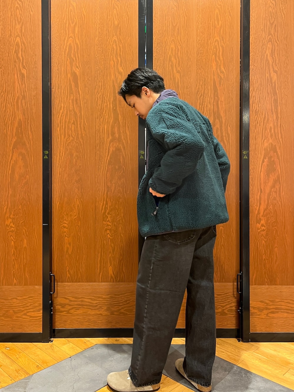 グリーン系のテーラードジャケット、グレー系のスウェット、パープル系のサンダルを着用したメンズの冬コーディネートの3枚目の写真