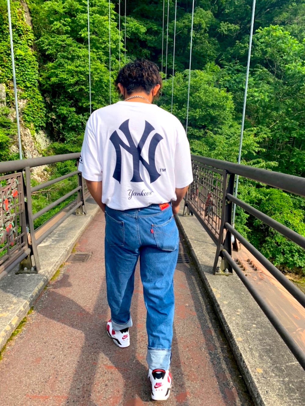 ホワイト系のTシャツ/カットソー、ブルー系のデニムパンツ、シルバー系のネックレスを着用したメンズの夏コーディネートの2枚目の写真