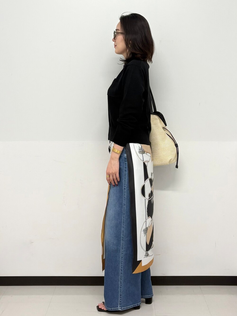 ブルー系のデニムパンツ、ブラック系のサンダル、ブラック系のカーディガン/ボレロを着用したレディースの春コーディネートの4枚目の写真