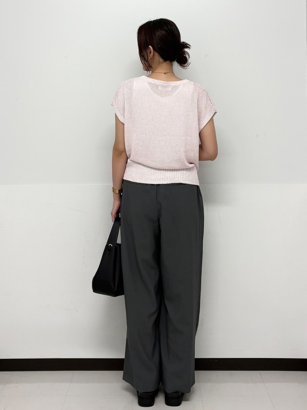 ピンク系のニット/セーター、グレー系のその他パンツ、ブラック系のトートバッグを着用したレディースの夏コーディネートの5枚目の写真