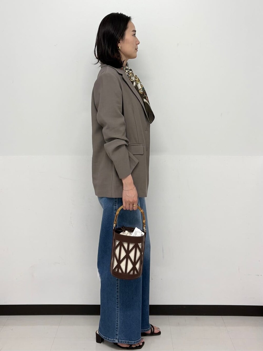 ブルー系のデニムパンツ、ホワイト系のその他パンツ、ブラウン系のテーラードジャケットを着用したレディースの春コーディネートの3枚目の写真
