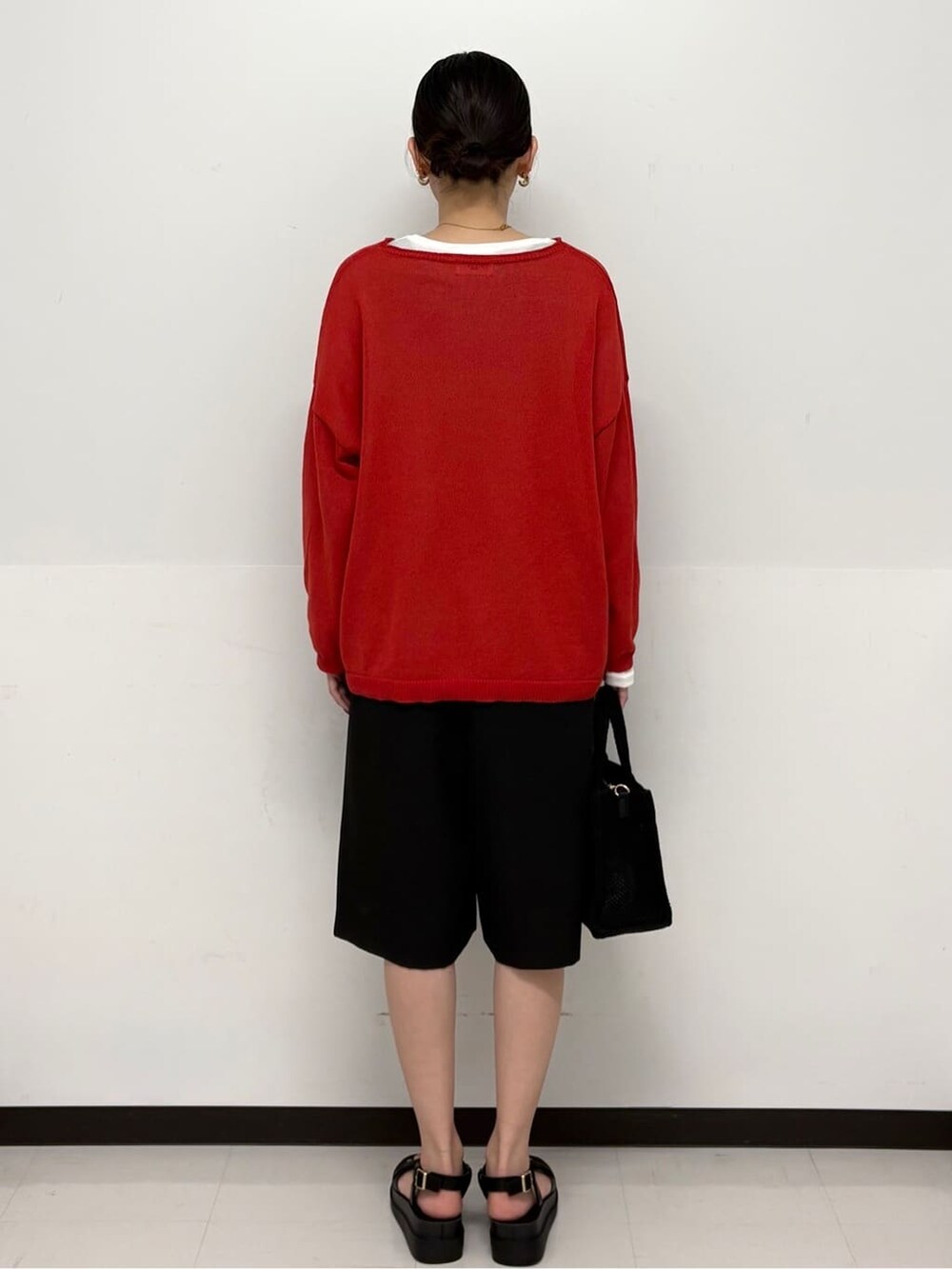 ブラック系のトートバッグ、ホワイト系のTシャツ/カットソー、ブラック系のサンダルを着用したレディースの春コーディネートの5枚目の写真
