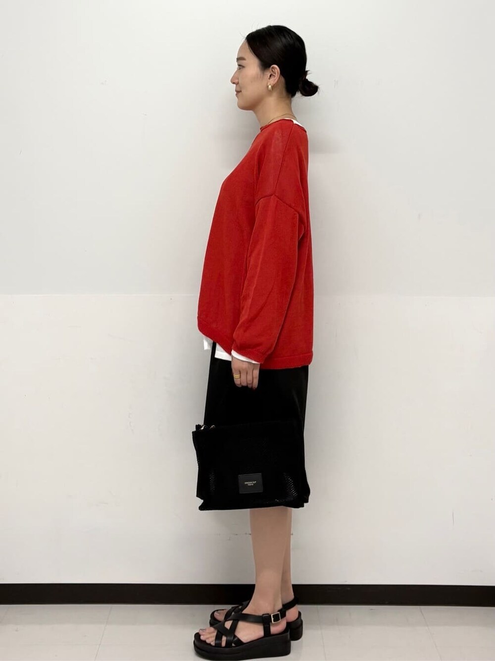 ブラック系のトートバッグ、ホワイト系のTシャツ/カットソー、ブラック系のサンダルを着用したレディースの春コーディネートの4枚目の写真