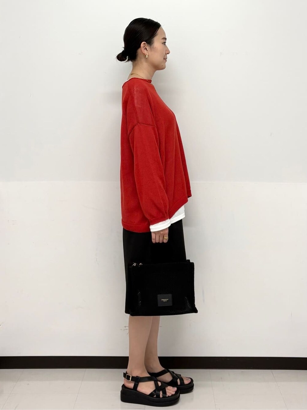 ブラック系のトートバッグ、ホワイト系のTシャツ/カットソー、ブラック系のサンダルを着用したレディースの春コーディネートの3枚目の写真