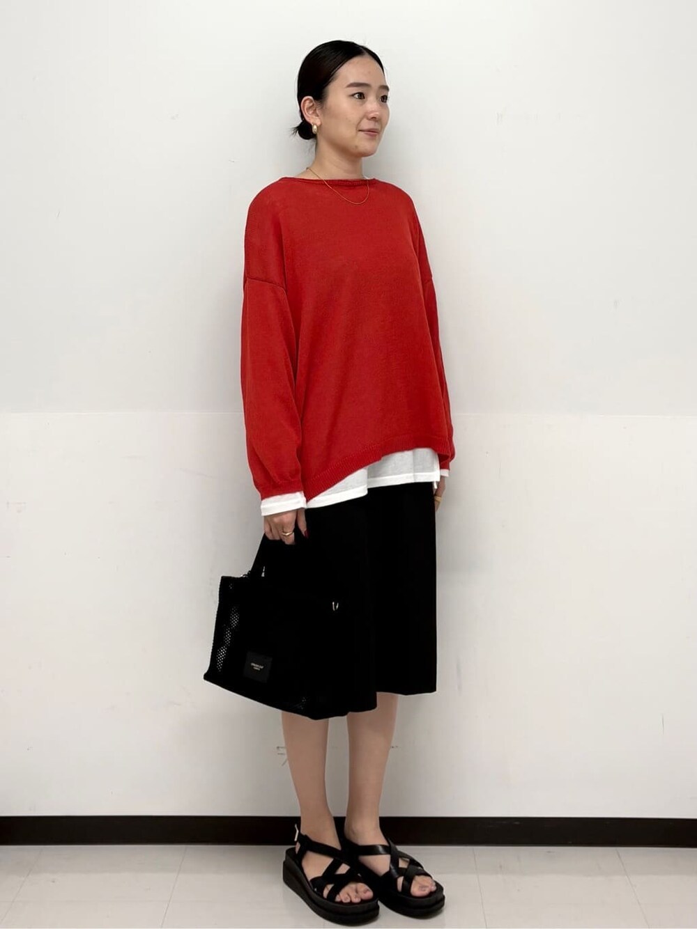 ブラック系のトートバッグ、ホワイト系のTシャツ/カットソー、ブラック系のサンダルを着用したレディースの春コーディネートの2枚目の写真