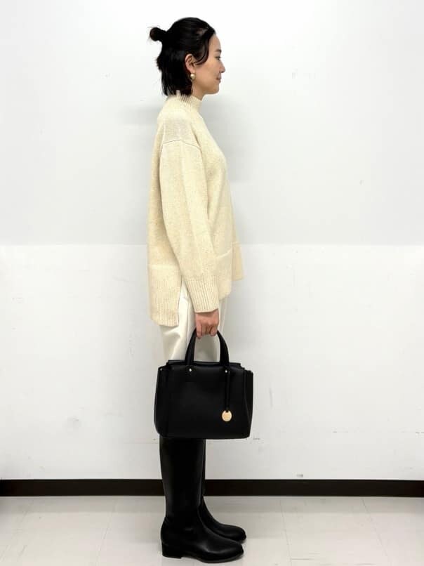 ベージュ系のニット/セーター、ホワイト系のその他パンツ、ブラック系のトートバッグを着用したレディースの秋コーディネートの3枚目の写真
