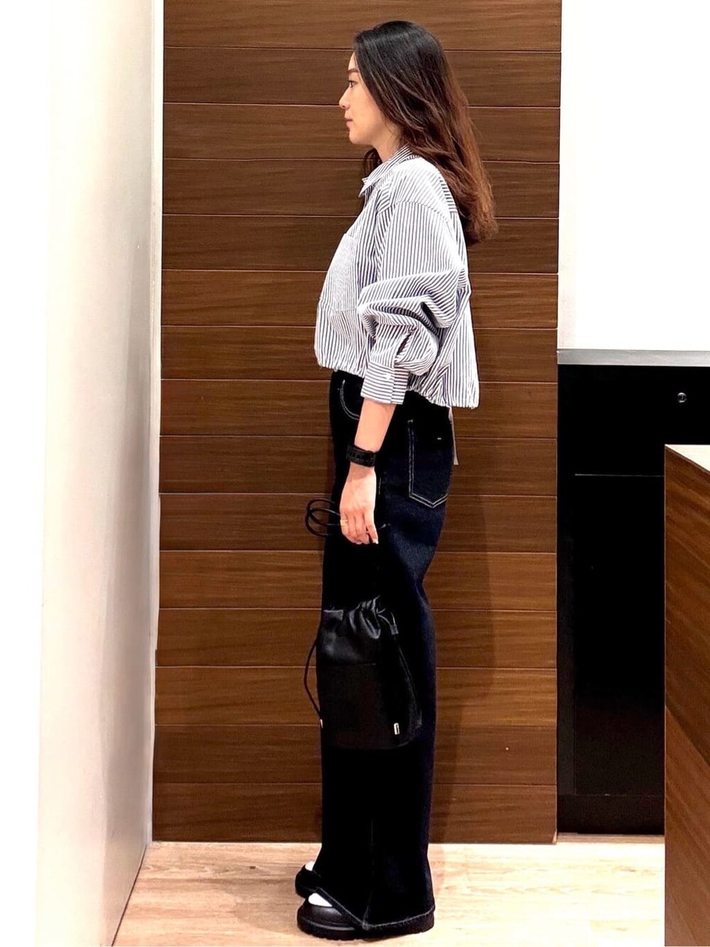 ブルー系のシャツ/ブラウス、ブルー系のデニムパンツ、ブラック系のショルダーバッグを着用したレディースの秋コーディネートの2枚目の写真
